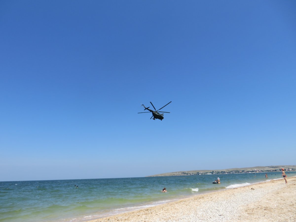 Russian helicopter over beach in Shcholkine, Crimea