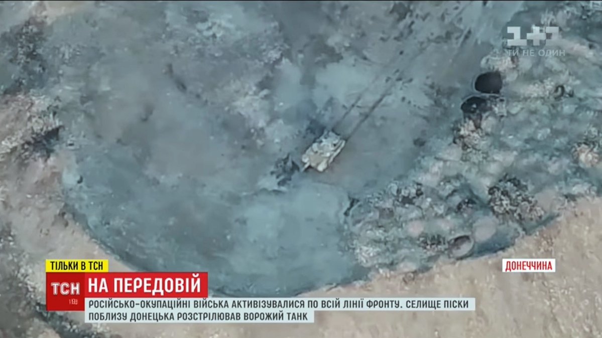 Ukrainian drone spots Russian tank firing on village of Pisky. From Russian occupied Donetsk, to get an elevated firing position, tank has driven up a large mine, slag heap. Pisky's been devastated by Russian artillery.