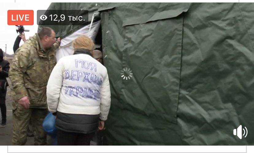 One of released prisoners, Ukrainian woman in jacket with handmade Trident and Ukraine is my country