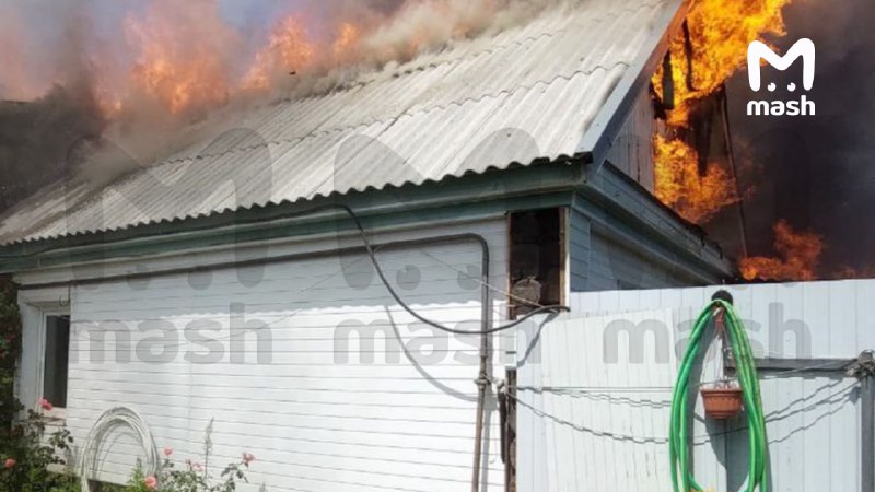 Várias casas em chamas após o bombardeio com MLRS GRAD na aldeia Belaya Berezka da região de Briansk